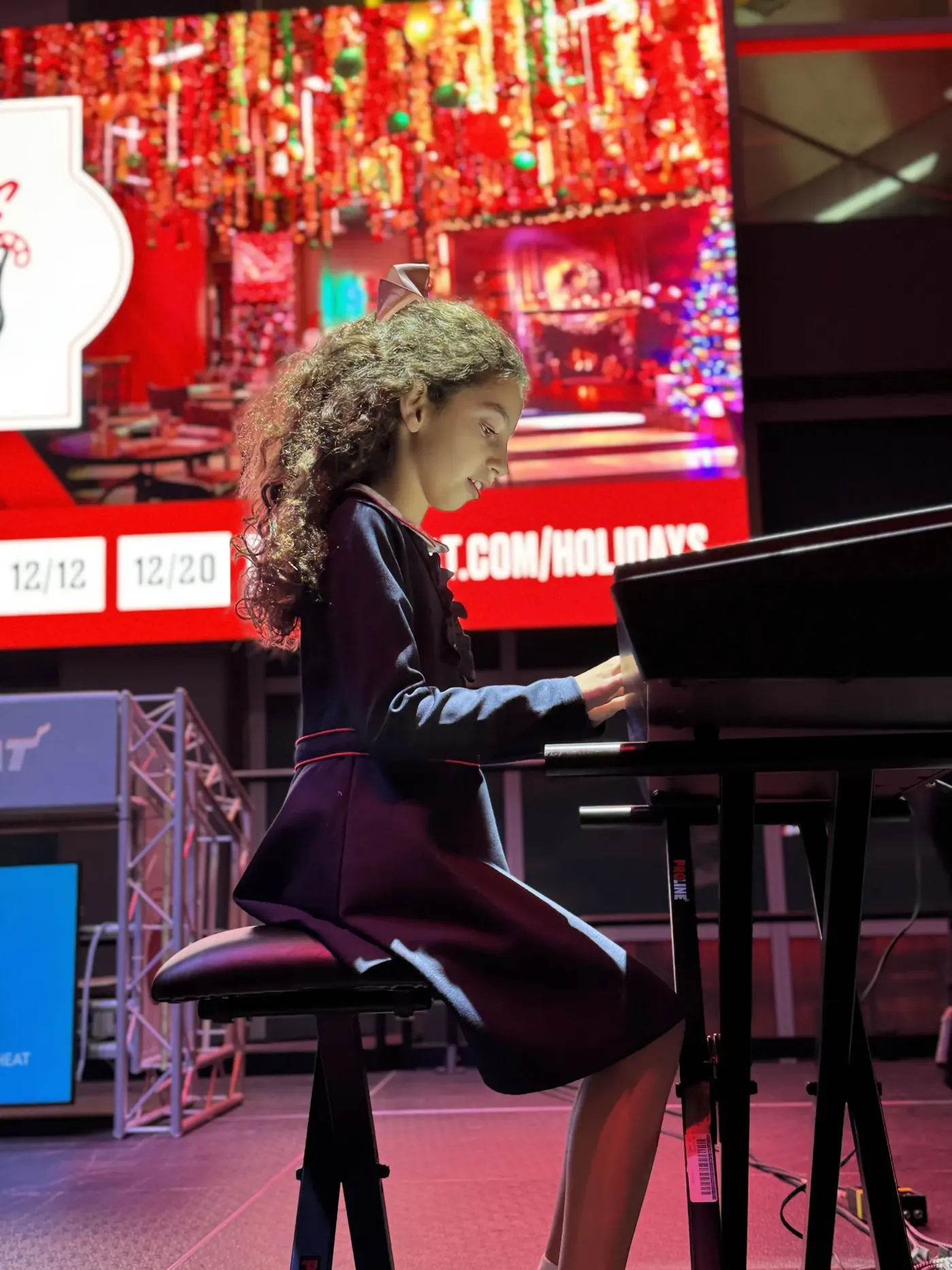 Young pianist performing at a holiday event at Kaseya Center